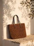 Bolso capazo tejido XL Menorca sobre pared blanca al atardecer